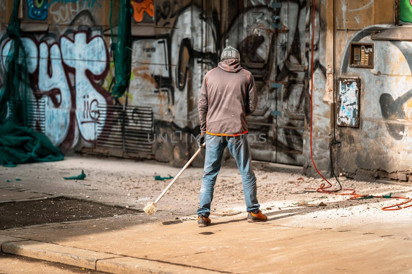 cleaning the city streets while repairing the facade of the house.
