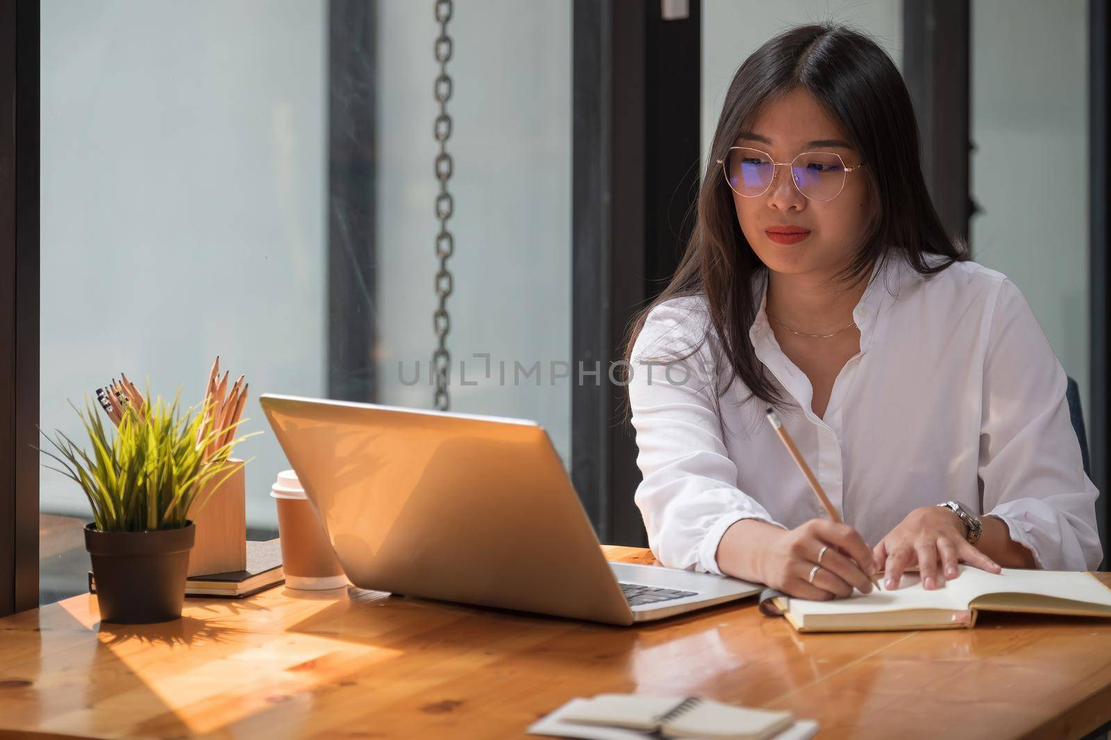 Student study online with teacher, happy young woman learn language listen lecture watch webinar write notes look at laptop sit in cafe, distant education