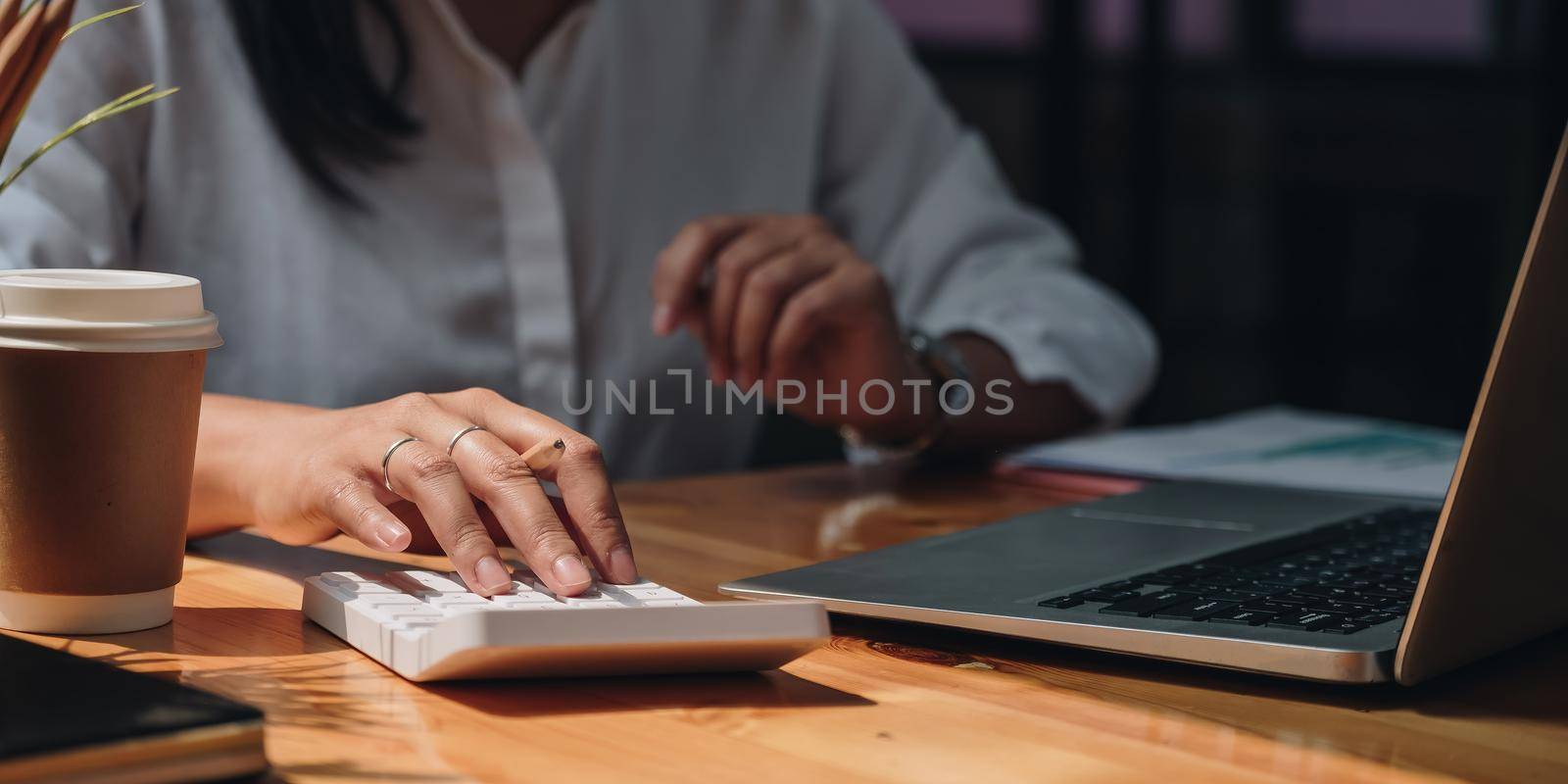 Business accounting concept, Business woman using calculator with computer laptop, budget tax and loan paper in office by nateemee