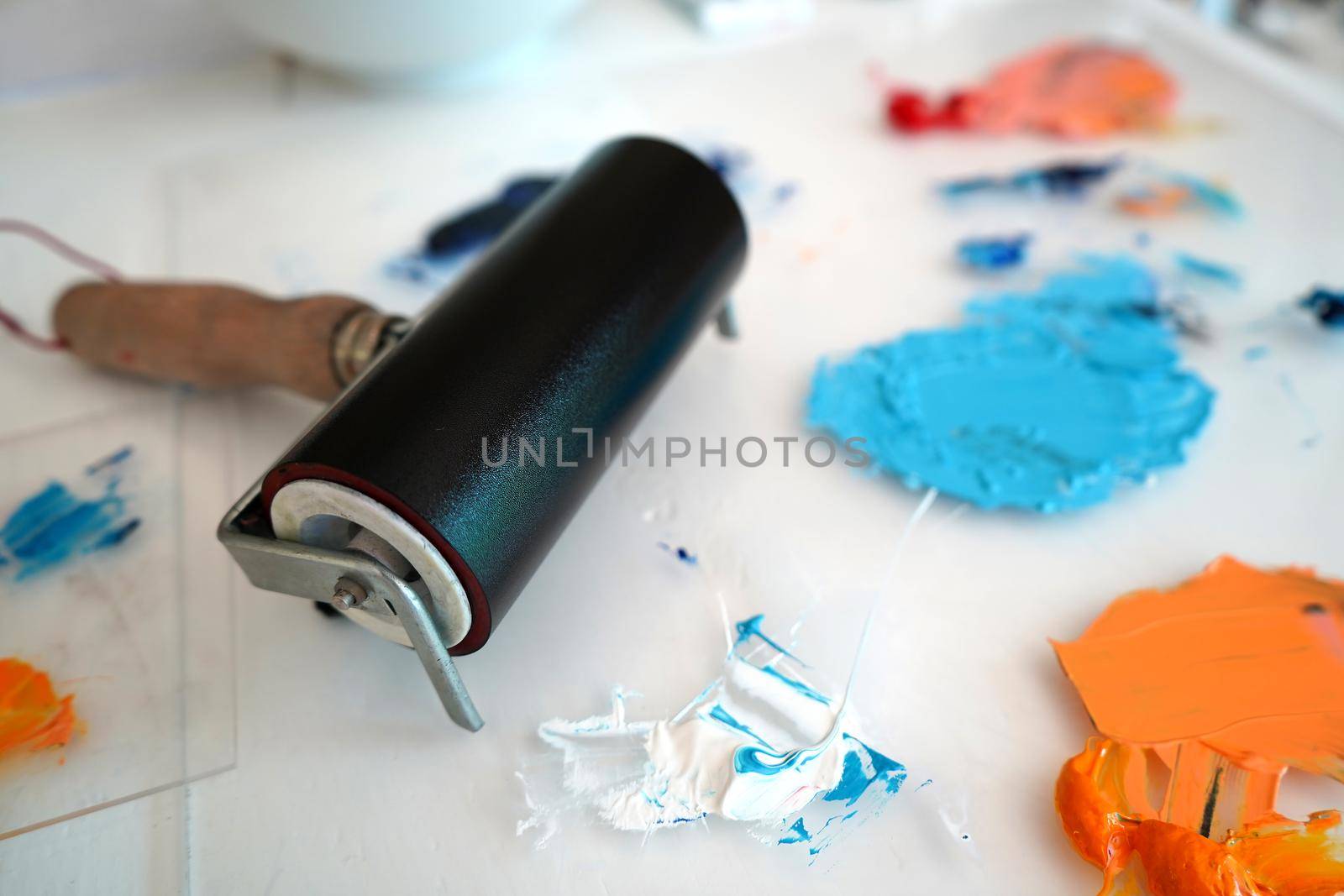 Detail of paint brushes and bright paint in an artist’s studio by fivepointsix