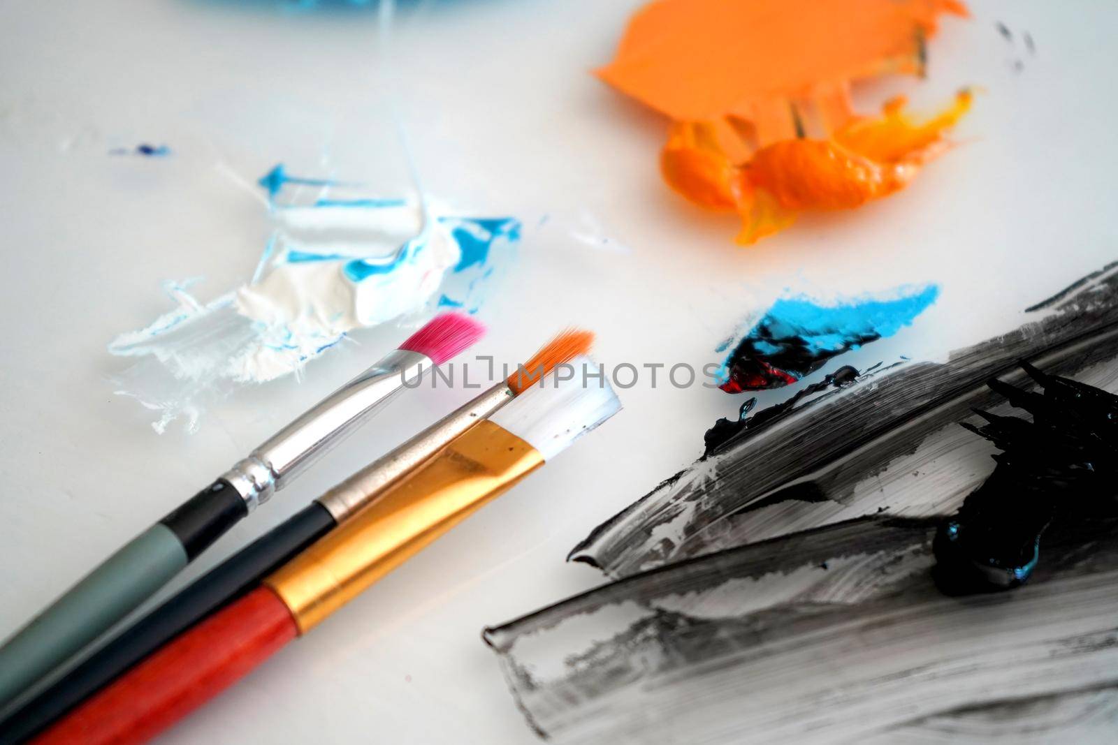 Detail of paint brushes and bright paint in an artist’s studio