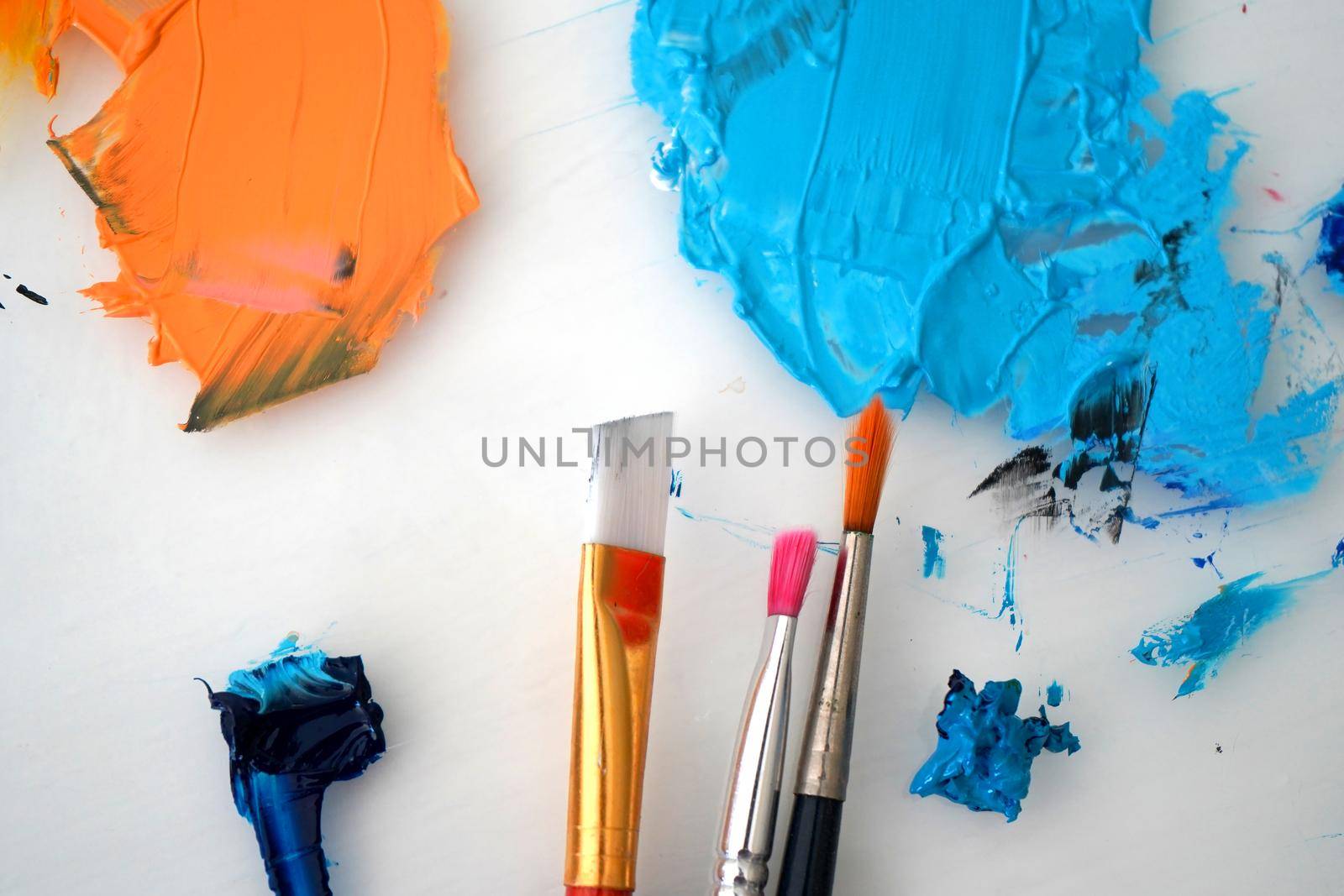 Detail of paint brushes and bright paint in an artist’s studio