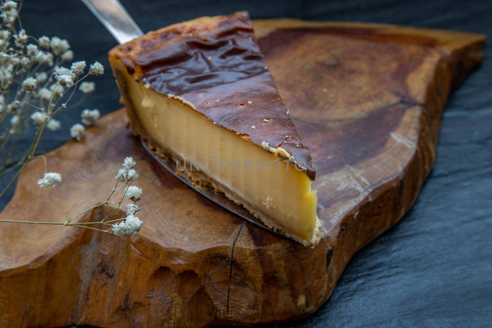 Slice of delicious fresh Tartellette creme brulee a la vanille on a wooden plate. Oblique view from the top.