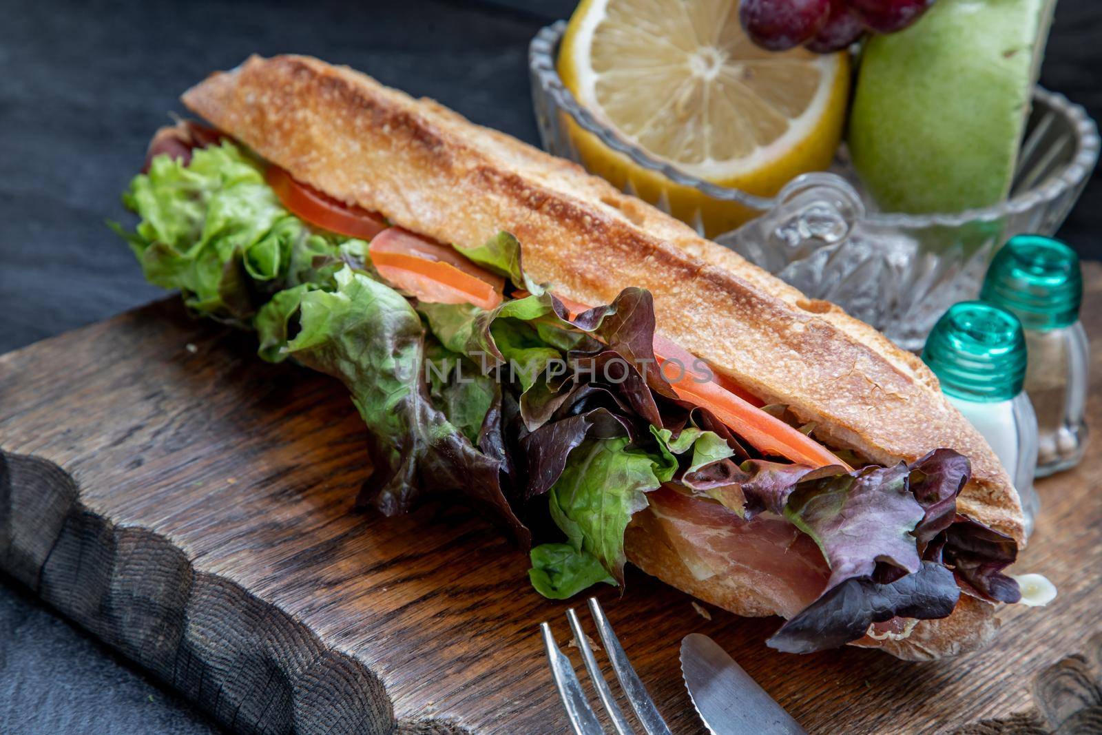 A delicious Smoked salmon sesame bread sandwich on a wooden plate. It is perfect eaten with salads and flavoursome cheeses. Healthy breakfast food.