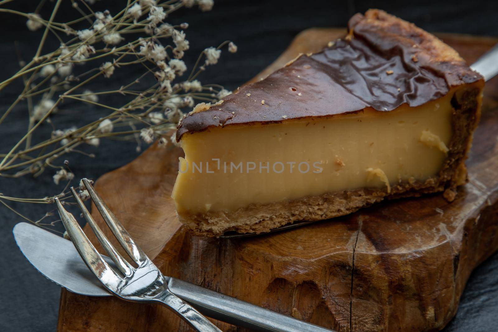 Slice of delicious fresh Tartellette creme brulee a la vanille on a wooden plate. Oblique view from the top.