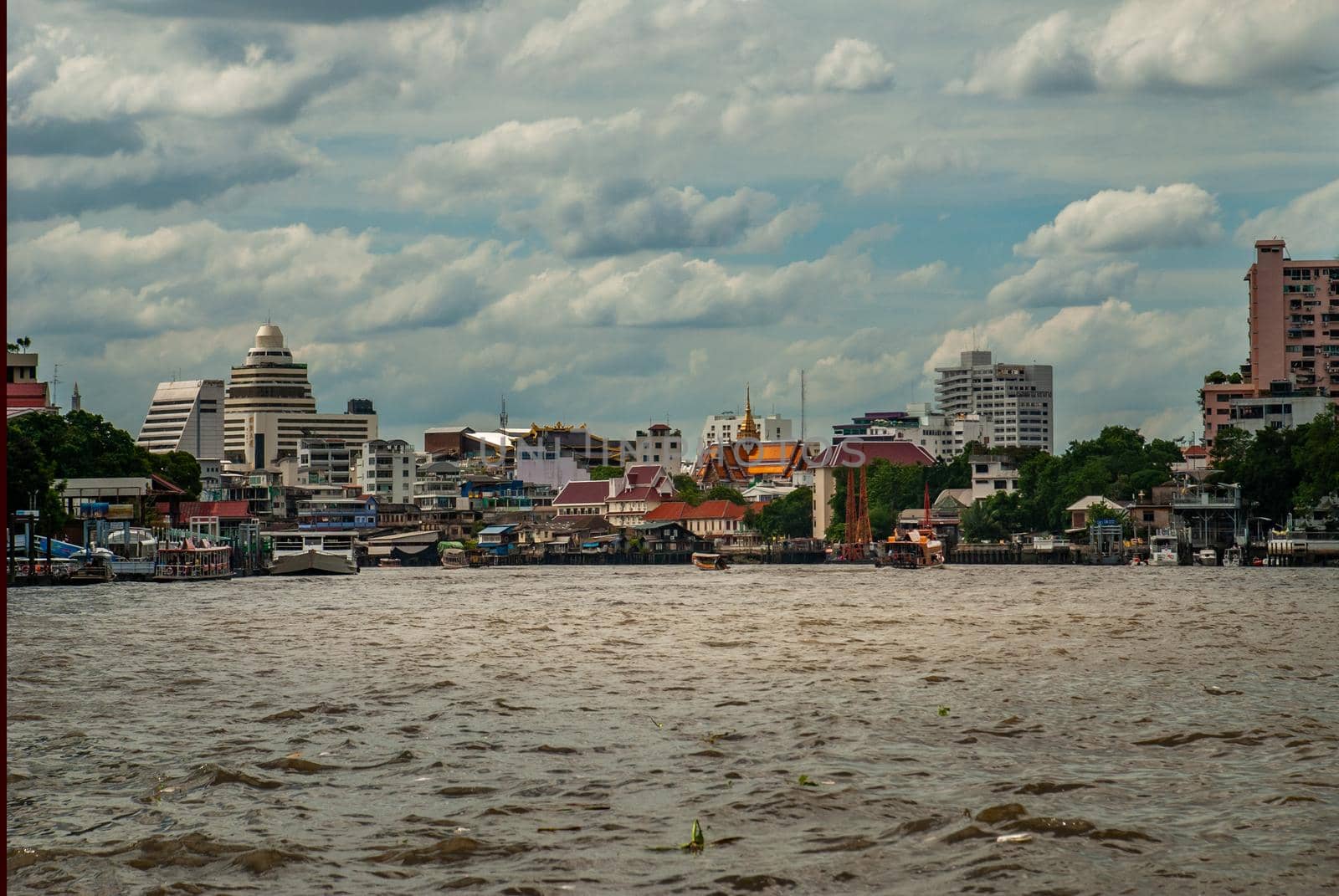 Bangkok, Thailand - 21 Jul 2019 : A view of the bank of Bangkok's Chao Phraya River showing the several tall buildings in the beautiful skyline.