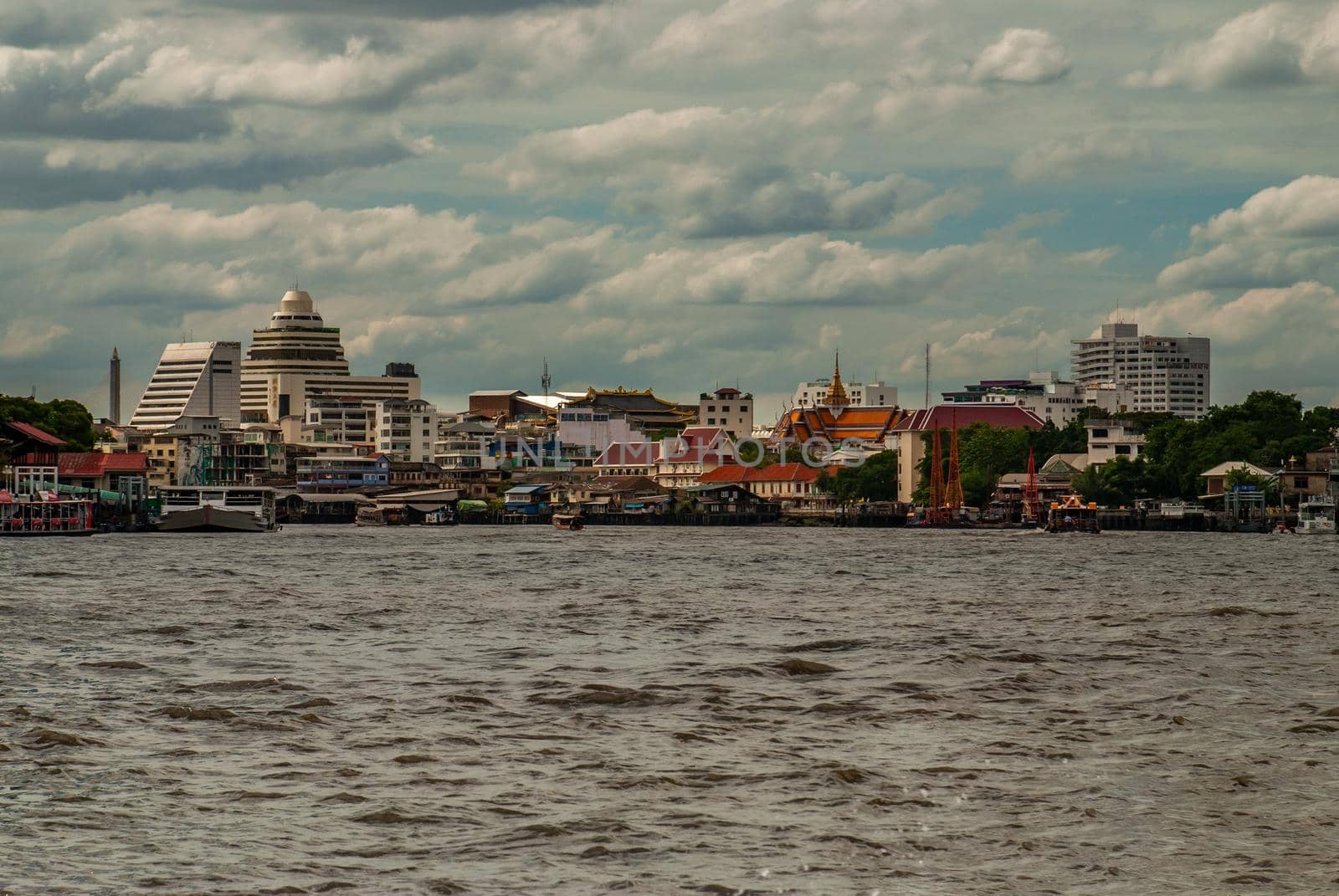 Bangkok, Thailand - 21 Jul 2019 : A view of the bank of Bangkok's Chao Phraya River showing the several tall buildings in the beautiful skyline.
