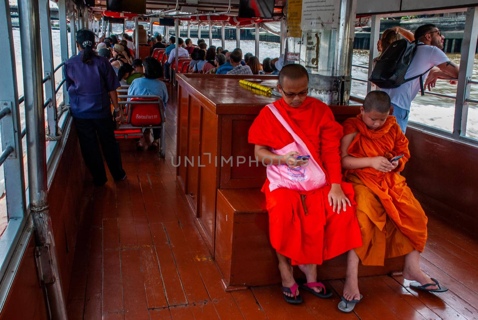 Bangkok, thailand 21 Jul, 2019 : The monks and novices are watching mobile messages during the Chao Phraya Express Boat Ride.