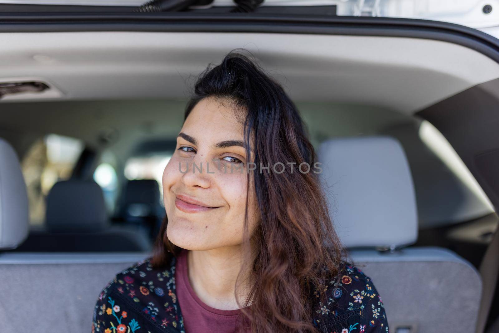 Beautiful woman smiling in the back of an SUV by Kanelbulle