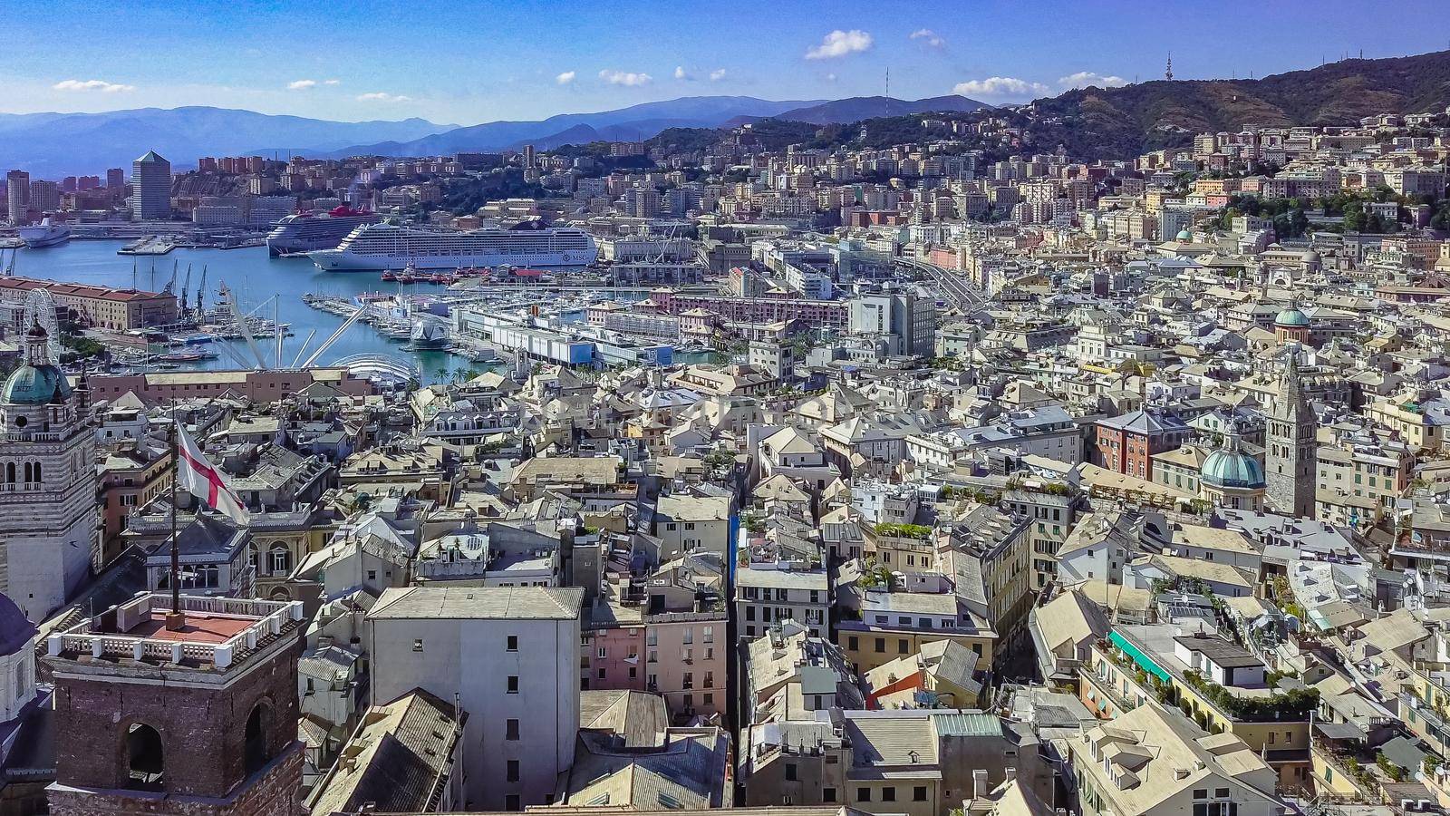 Aerial panoramic drone view of buildings and streets surrounding Port of Genoa.Cruise ships and ferries in port.Old famous city of Italy, with beautiful architecture, houses, roofs, buildings.