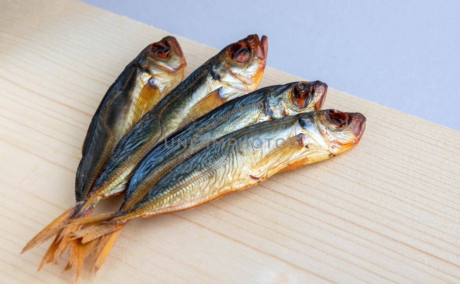 Horse mackerel fish, cold smoked. Smoked fish close-up on a wooden background .Food industry.