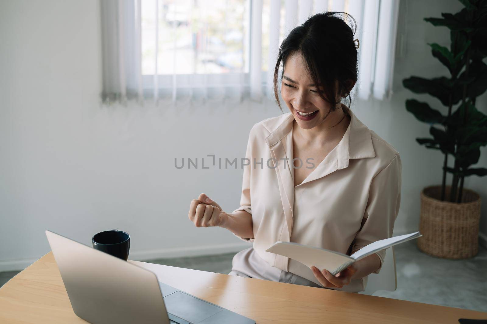 Excited Asian Businesswoman Celebrating Success At Workplace