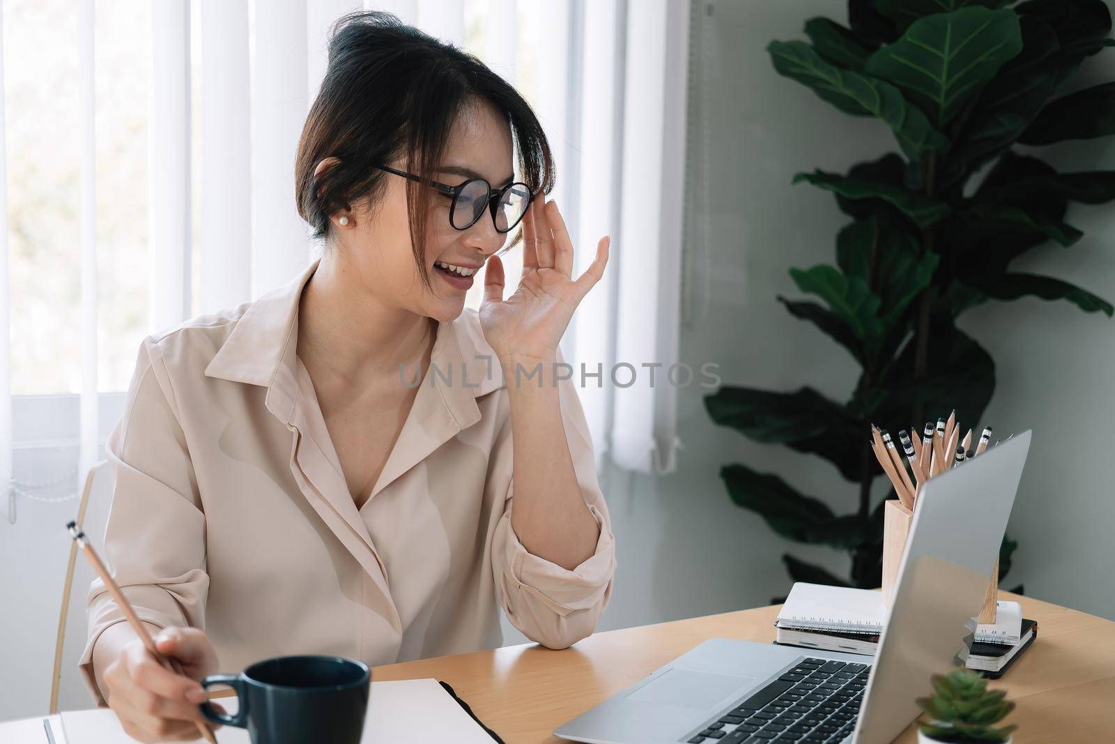 Young asian female student with glasses study with a laptop for online learning at home.