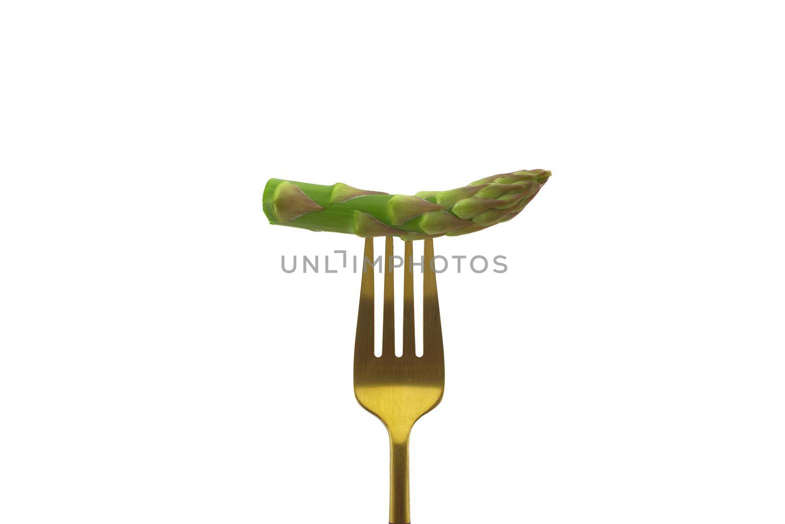 Asparagus pinned on a golden fork isolated on a white background