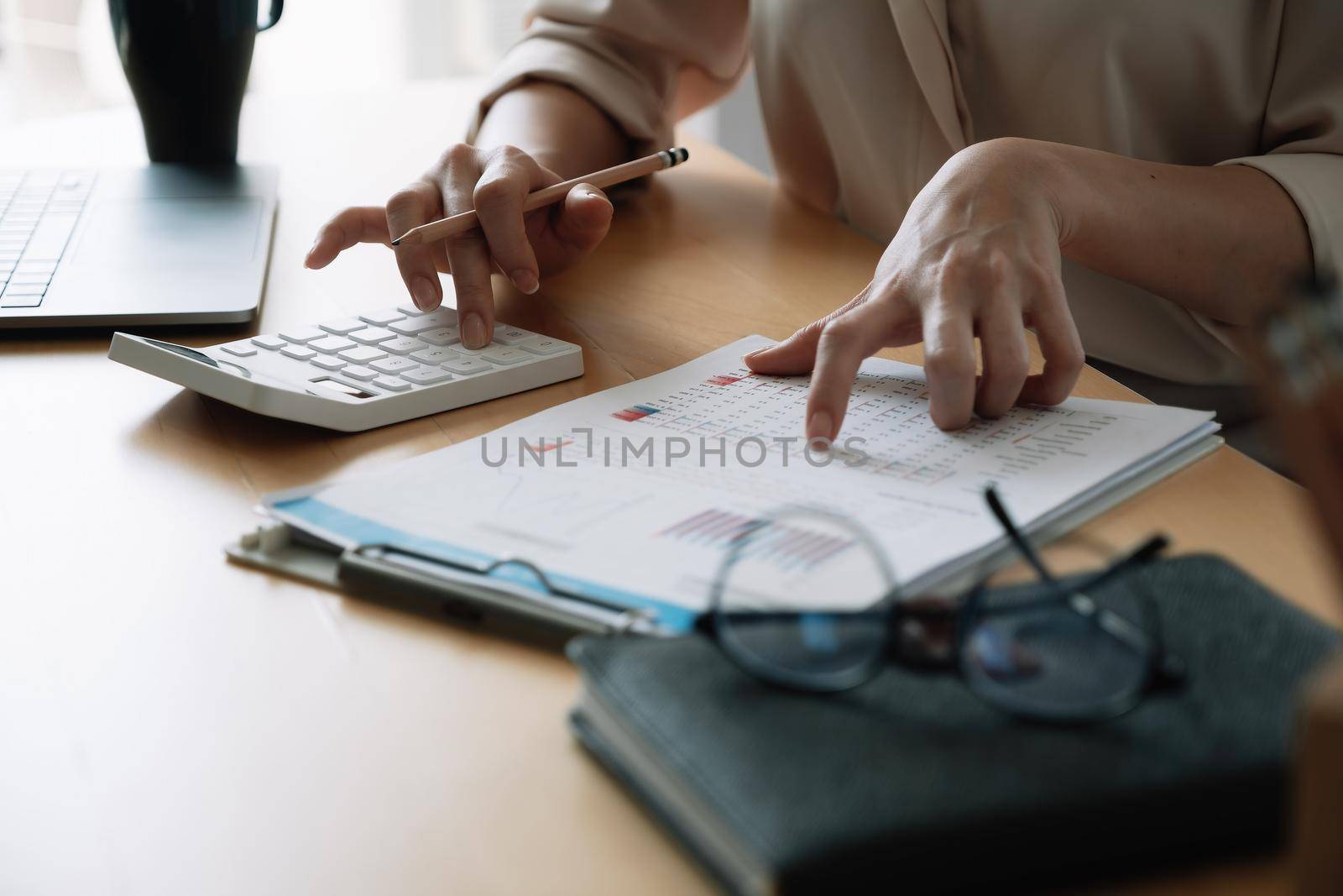 Close up Business woman or accountant using calculator with computer laptop, Business accounting, budget and loan paper at home.