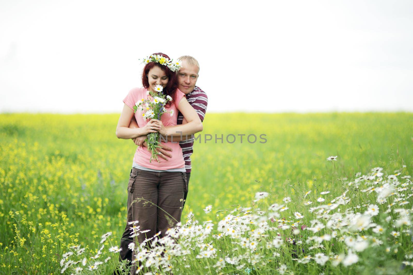 Enamored guy and girl in a green park with white daisies. 