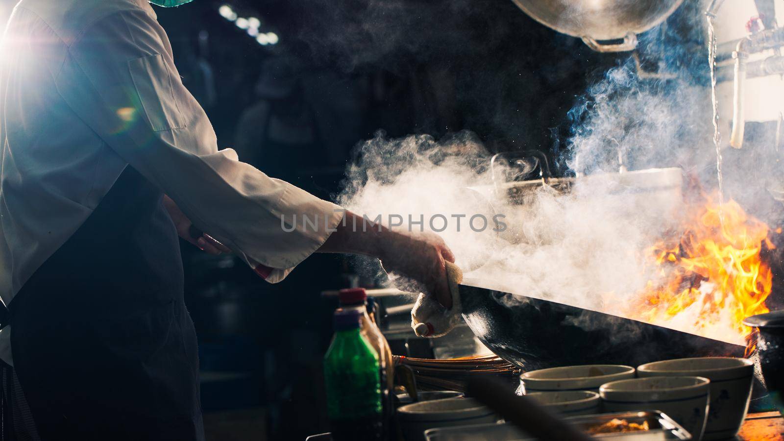 Chef stir fry in wok by Wasant