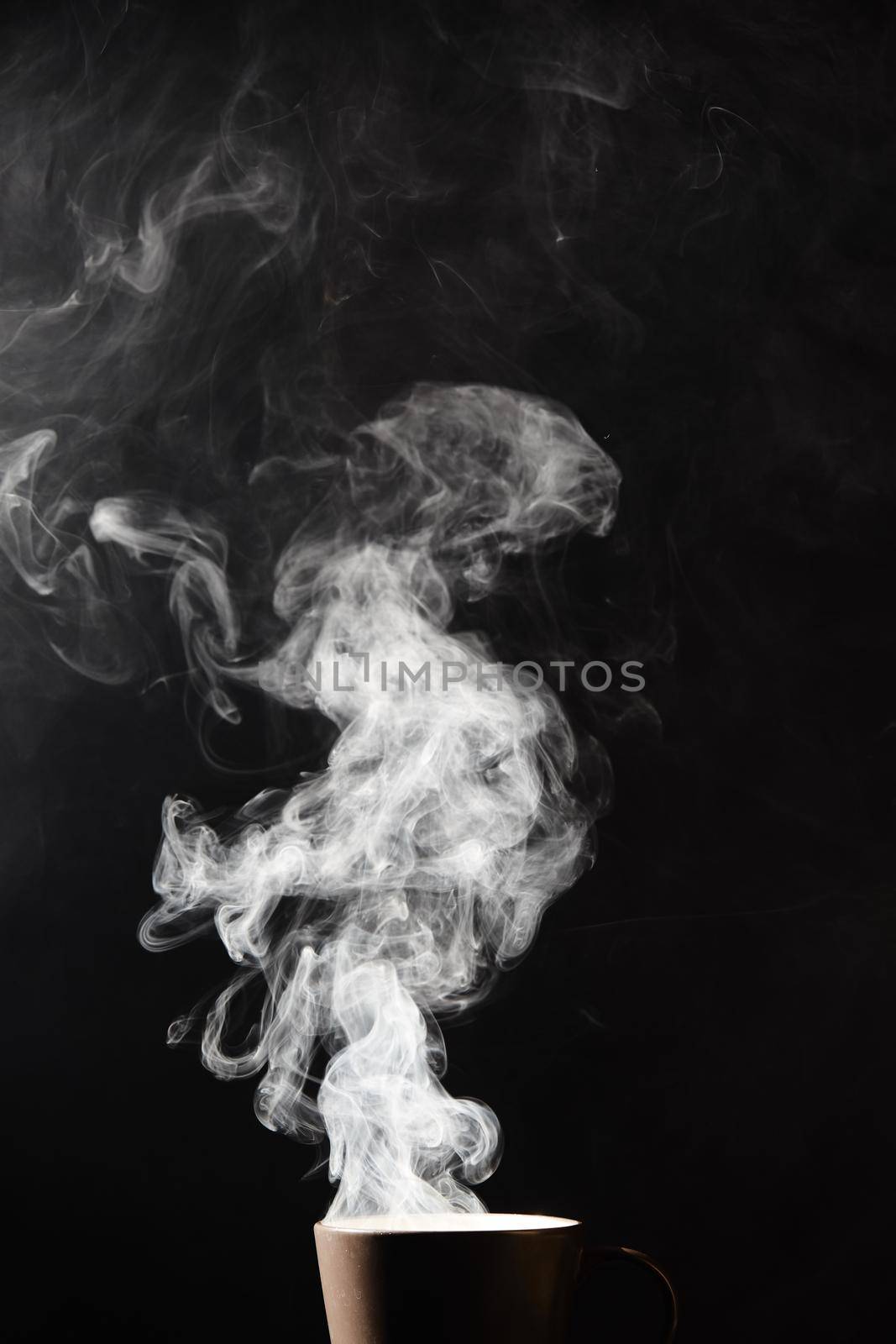 Steaming coffee cup on dark background, White smoke on dark