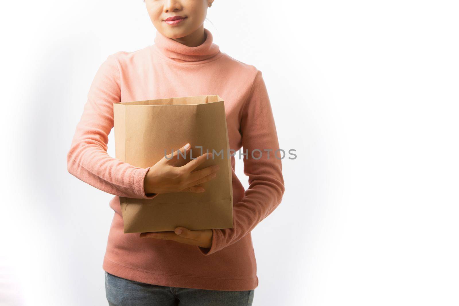 Young woman holding empty paper bag for merchandise on white background. Isolated on white