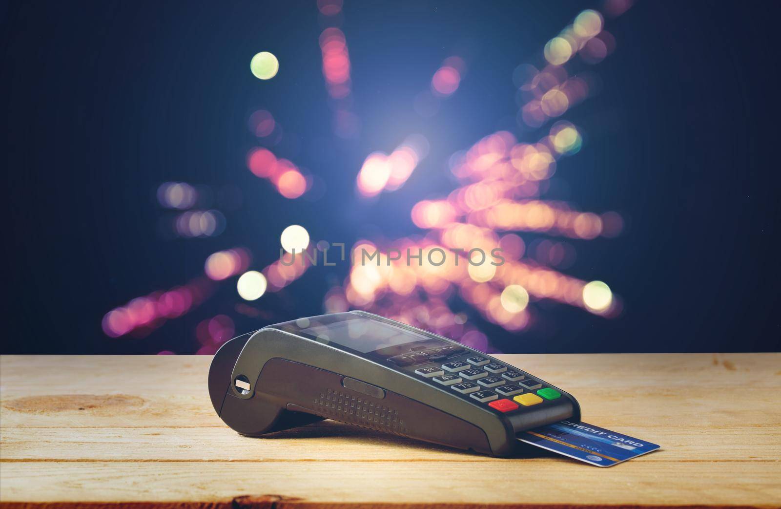 Credit card machine on wood with firework bokeh background