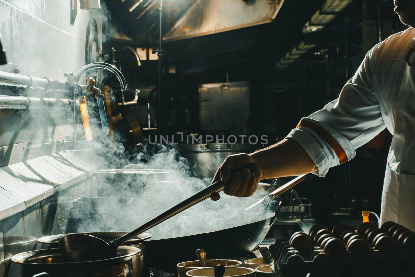 Chef stir fry in wok. Dramatic cooking with fire hard