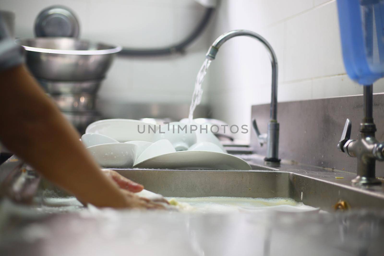 Woman washing dish by Wasant