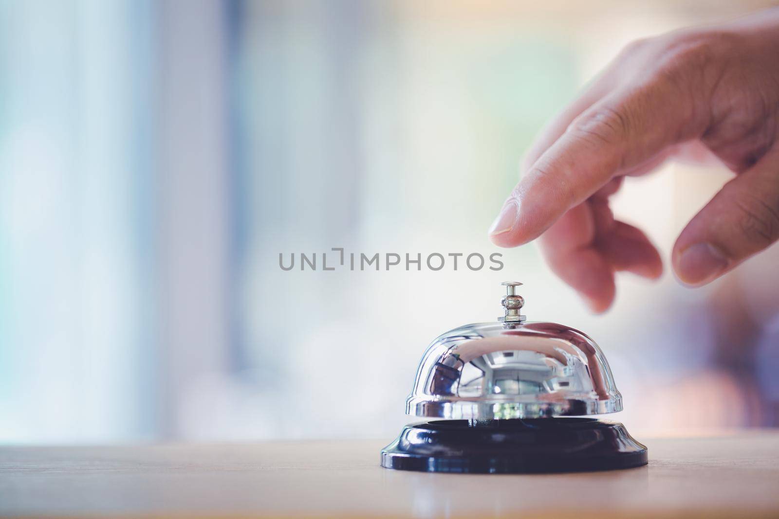 Bell on counter for service with hand. Ring the bell