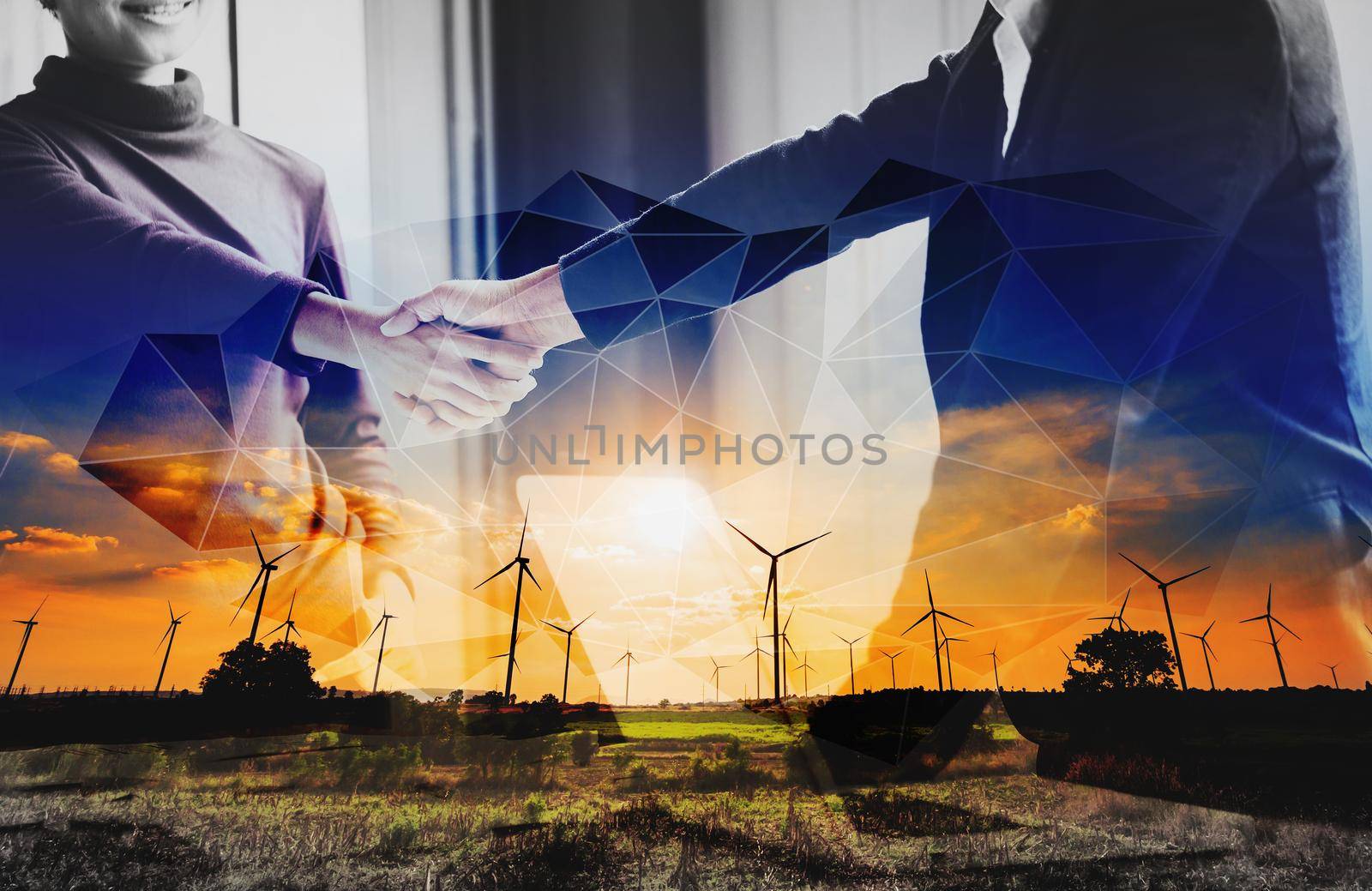 Double exposure of two business persons shaking hands and turbine energy wind
