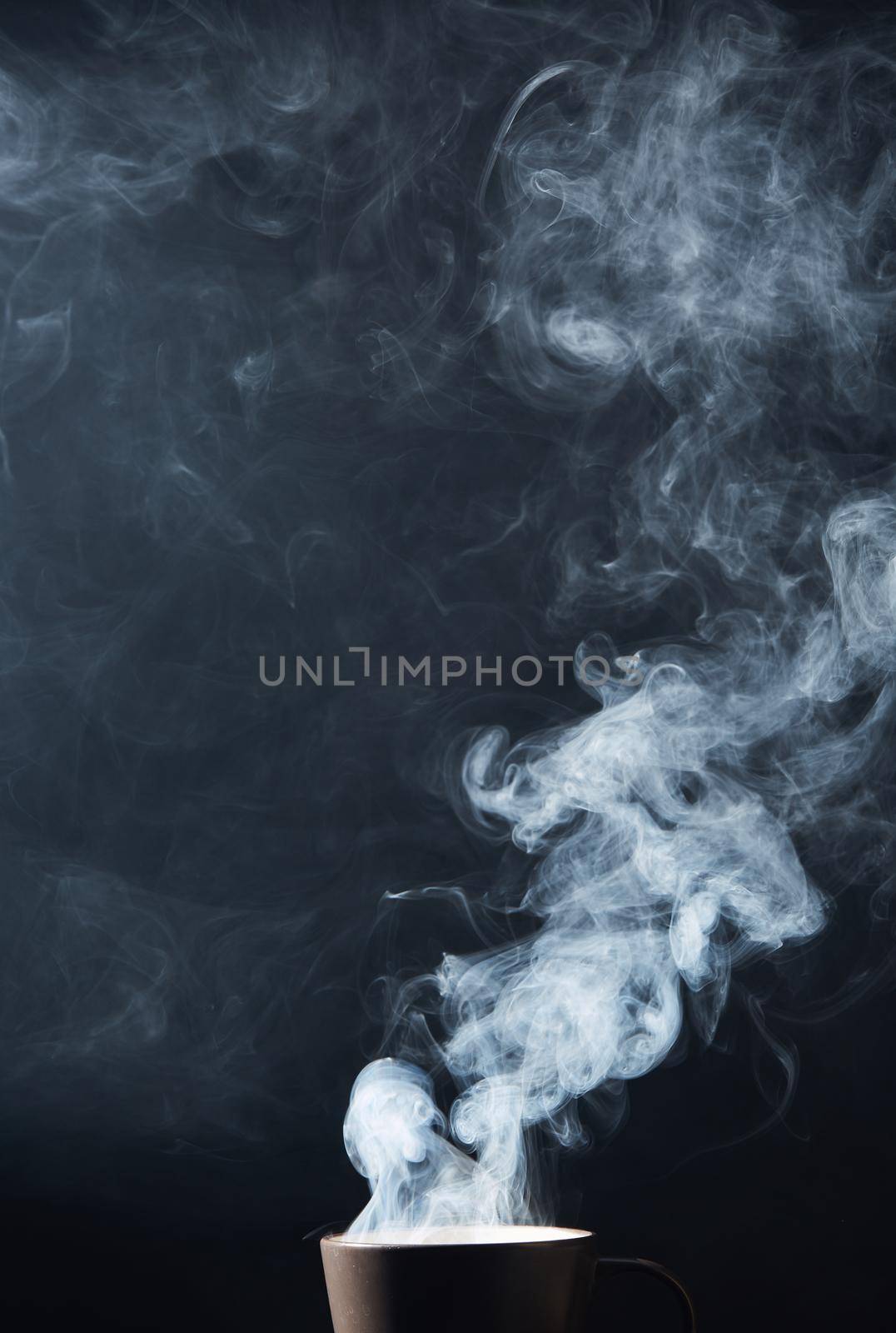 Steaming coffee cup on dark background, White smoke on dark