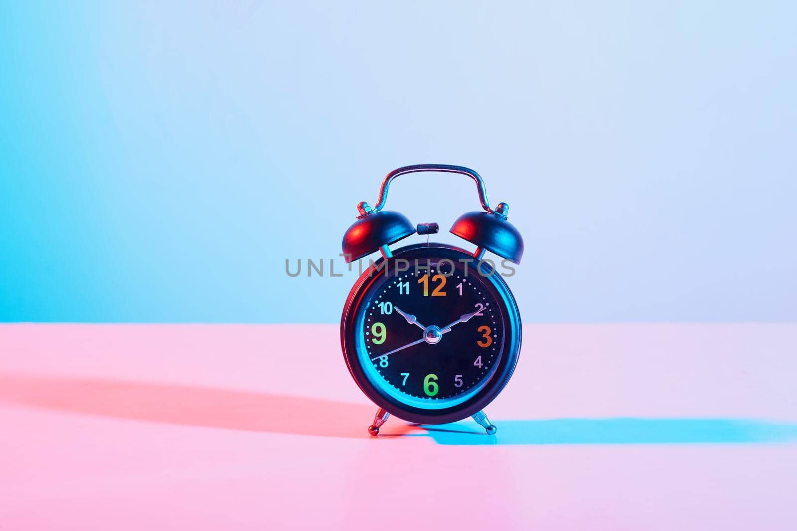 Alarm Clock with futuristic colorful lighting . Take photo on studio