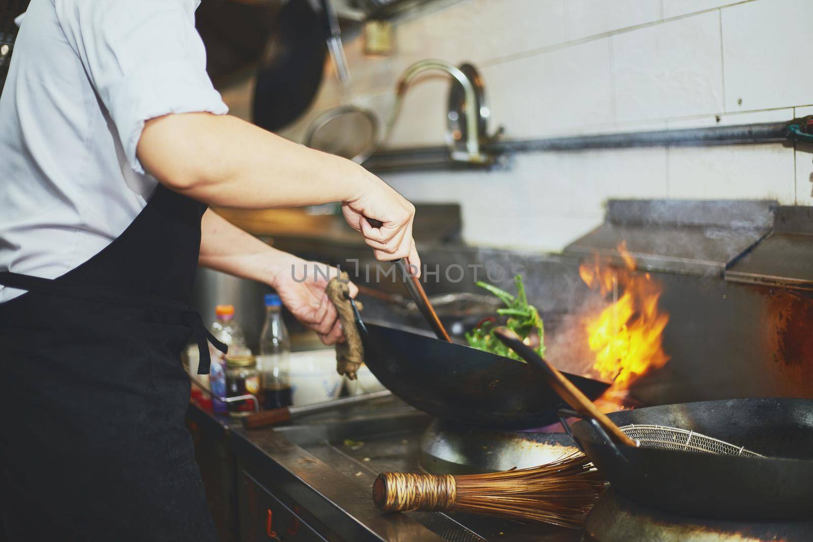 Chef stir fry busy cooking in kitchen 
