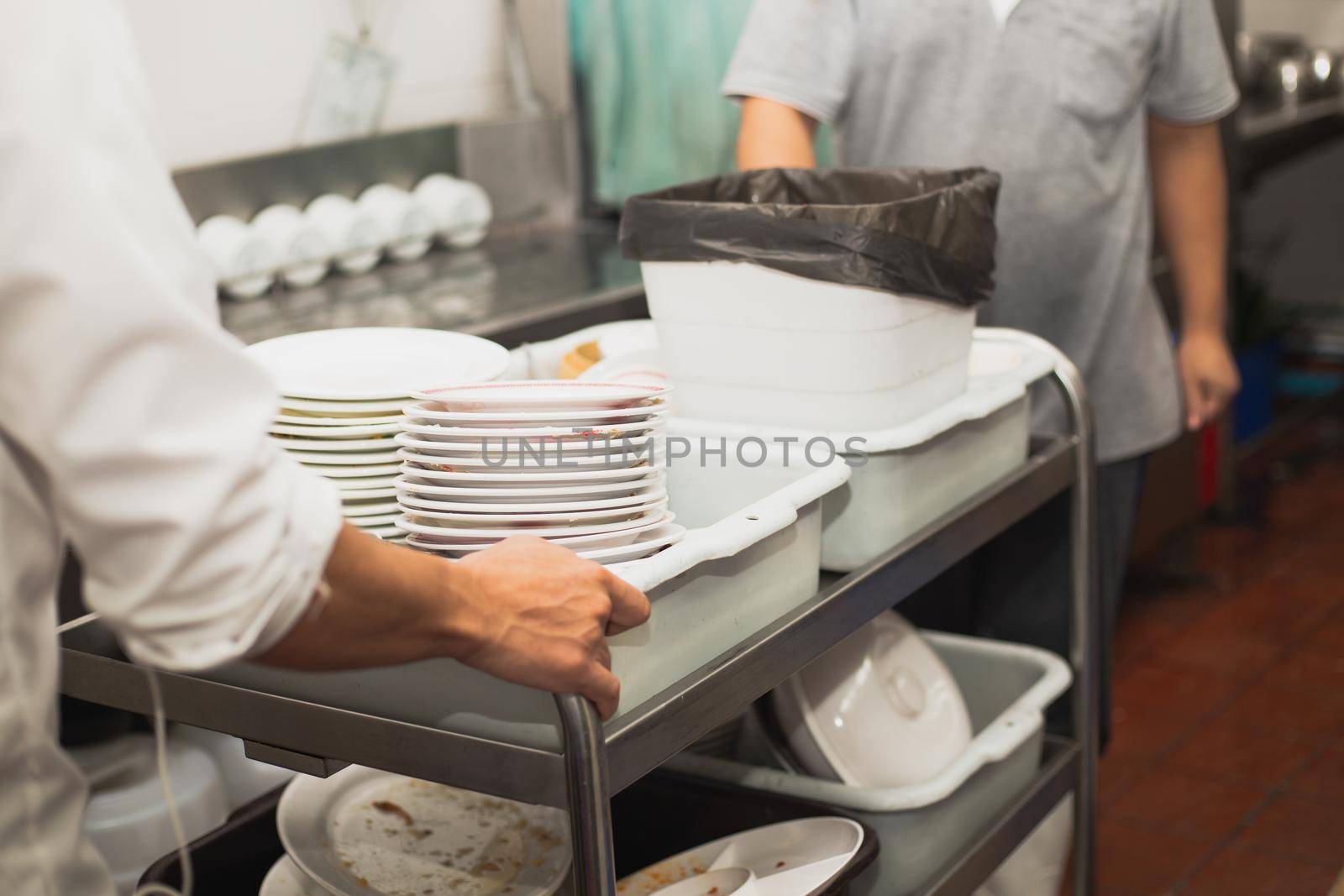 Man washing dish on sink at restaurant