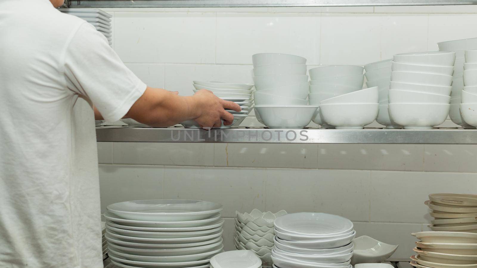 Man washing dish on sink at restaurant