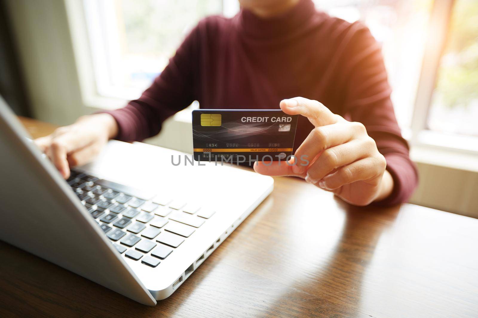 Hands holding plastic credit card and using notebook. Online shopping lifestyle concept