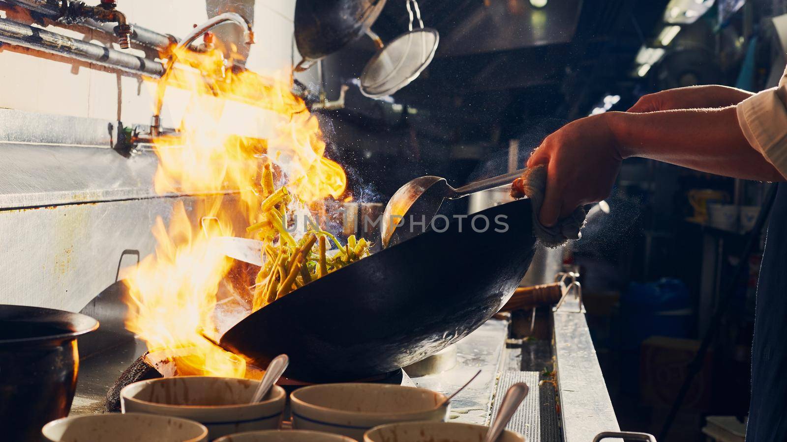 Chef stir fry cooking in kitchen