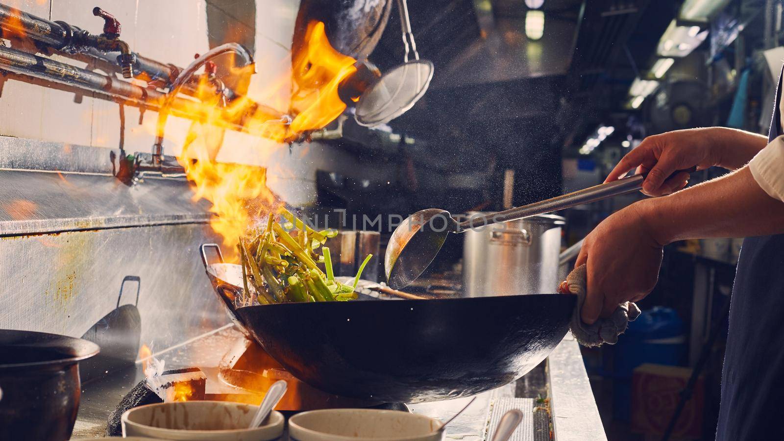 Chef stir fry cooking in kitchen