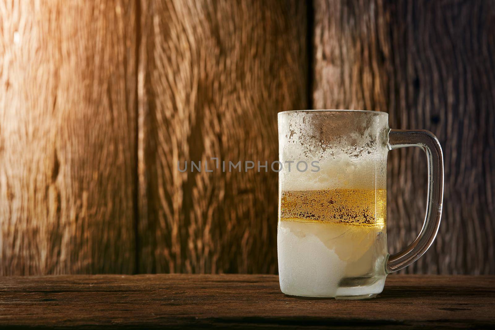 Beer in mug on wooden table with wooden background