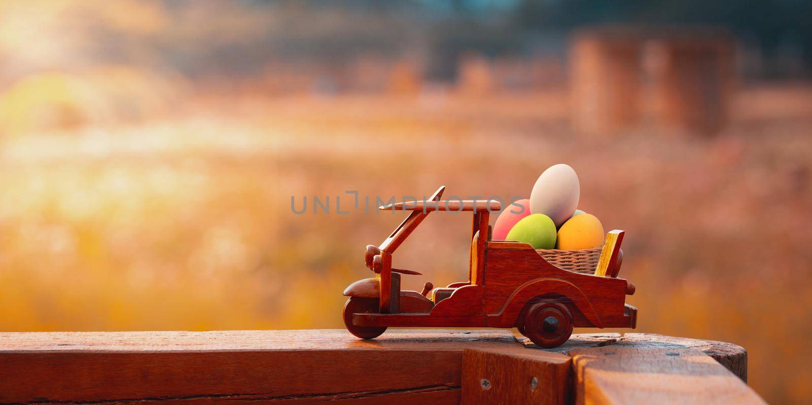 Three wheel taxi wooden toy  with eggs easter on garden with morning sunlight. Tuk Tuk Thailand. Panoramic photo