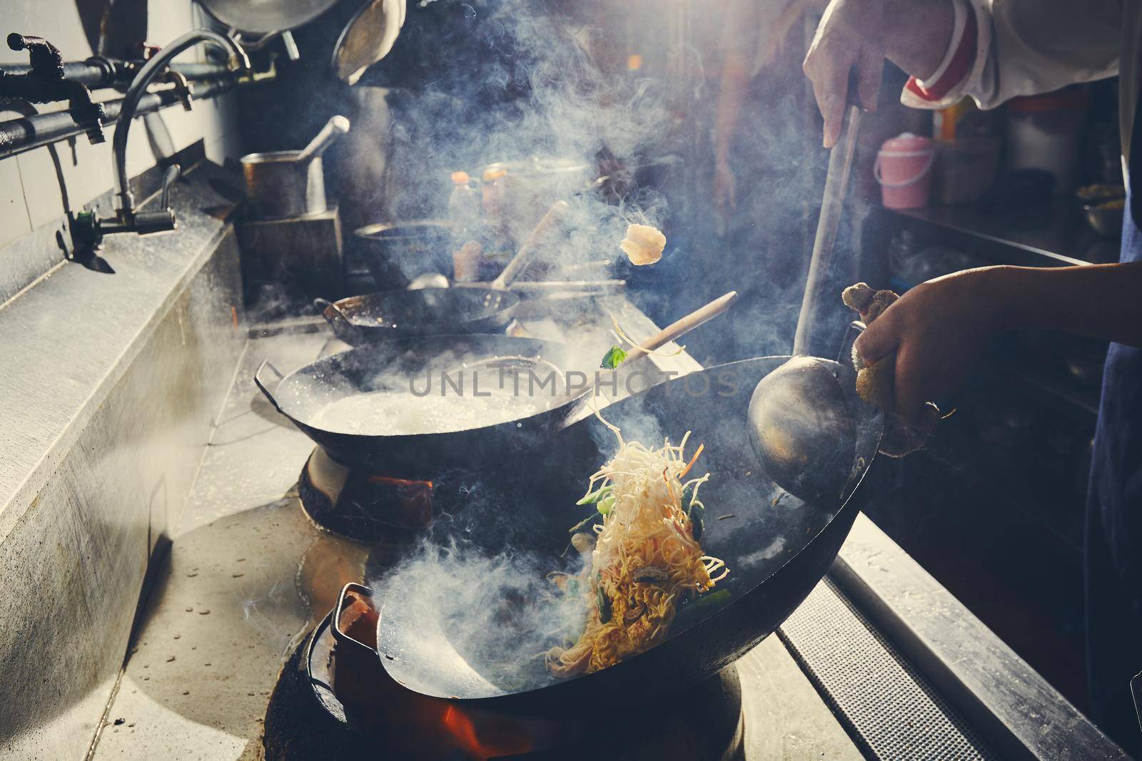 Chef stir fry cooking in kitchen