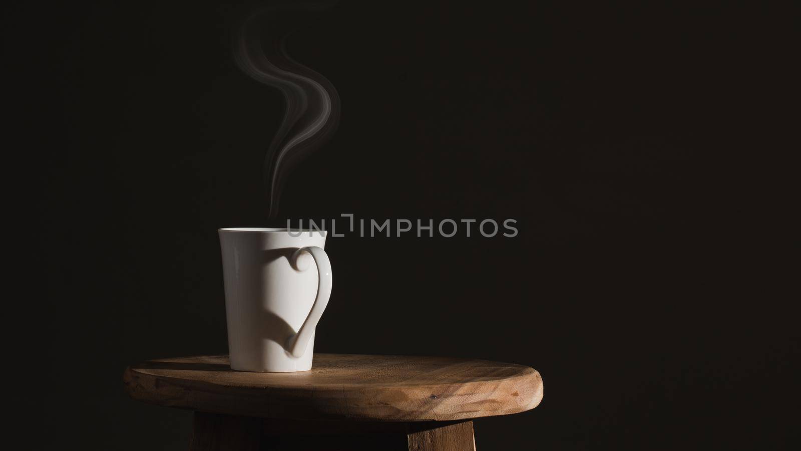 Shadow heart shape  of love with coffee cup on dark background