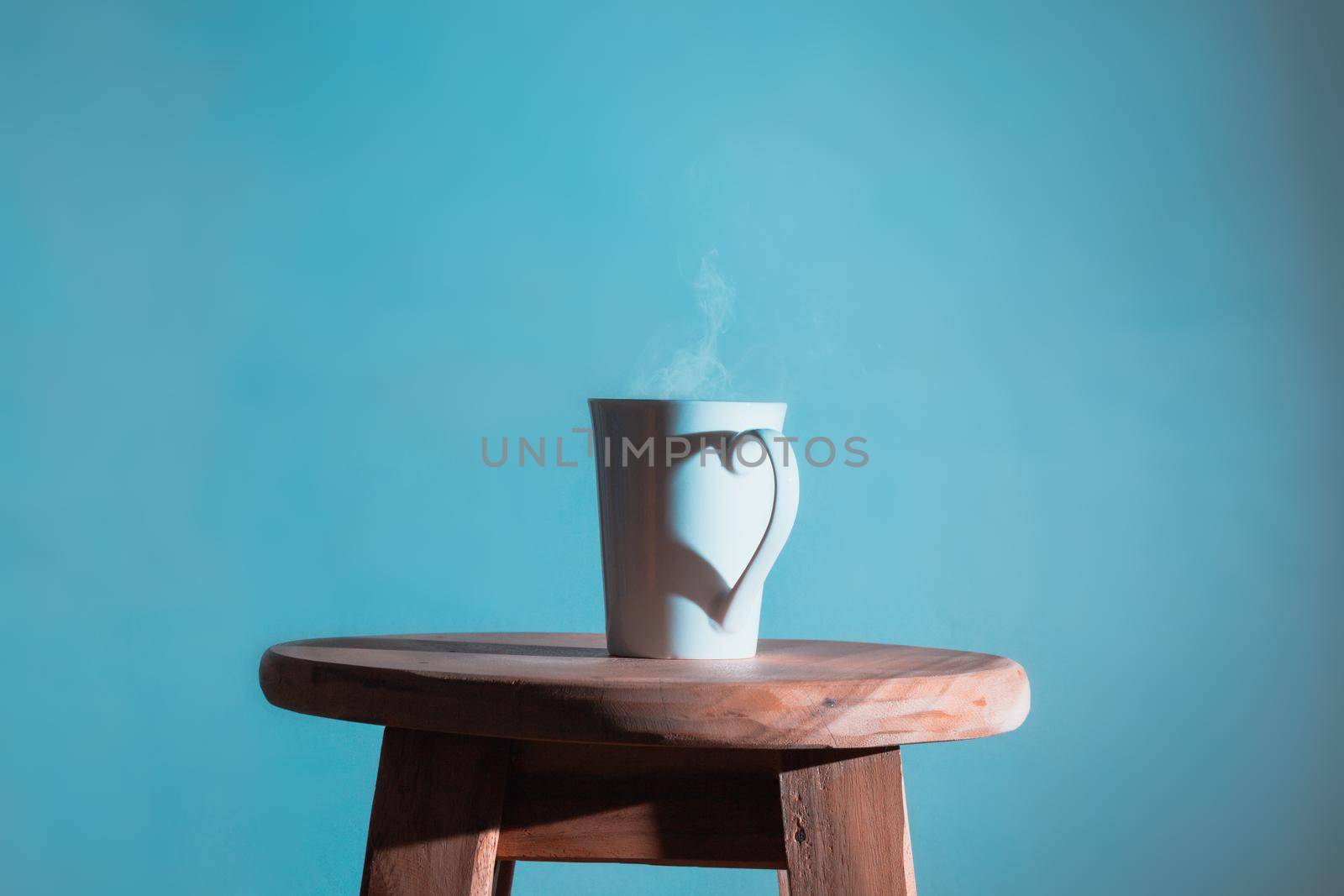 Shadow heart shape  of love with coffee cup on sweet blue color