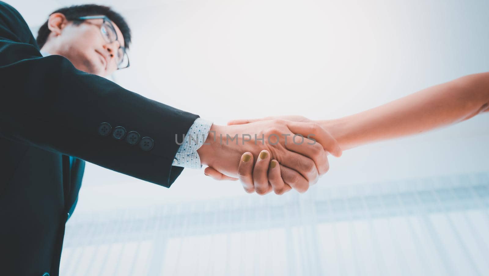 Businessman shaking female hand,Below angle of successful associates handshaking