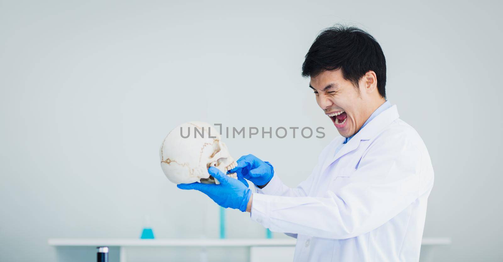 Medical science student playing with skulls with fun in a laboratory.