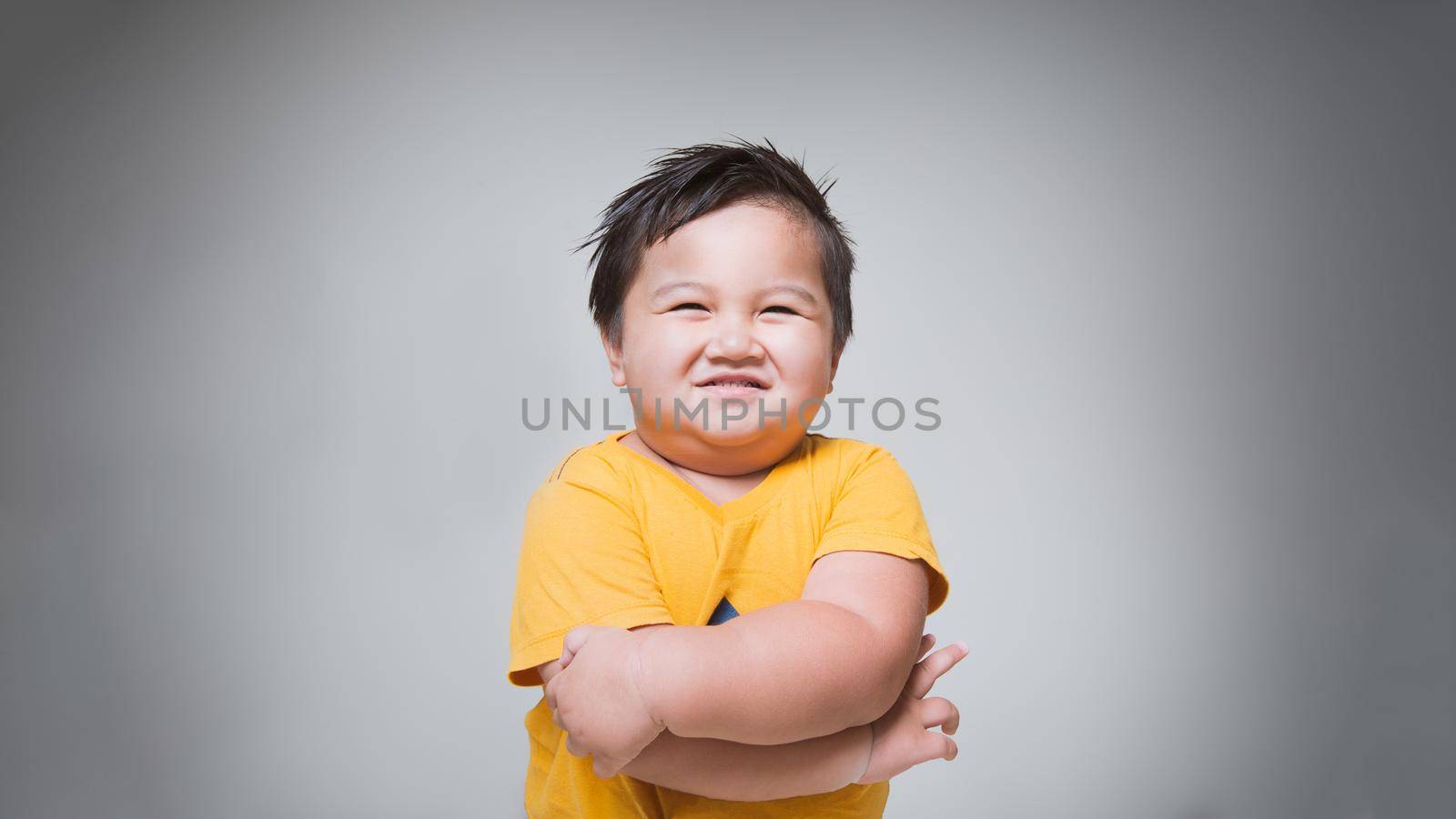 Little asian boy is smile on gray background