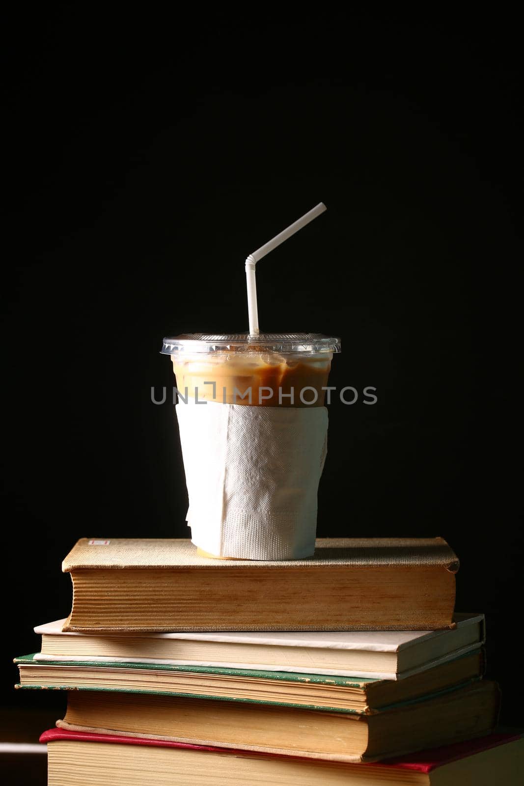 Ice coffee with book on dark background