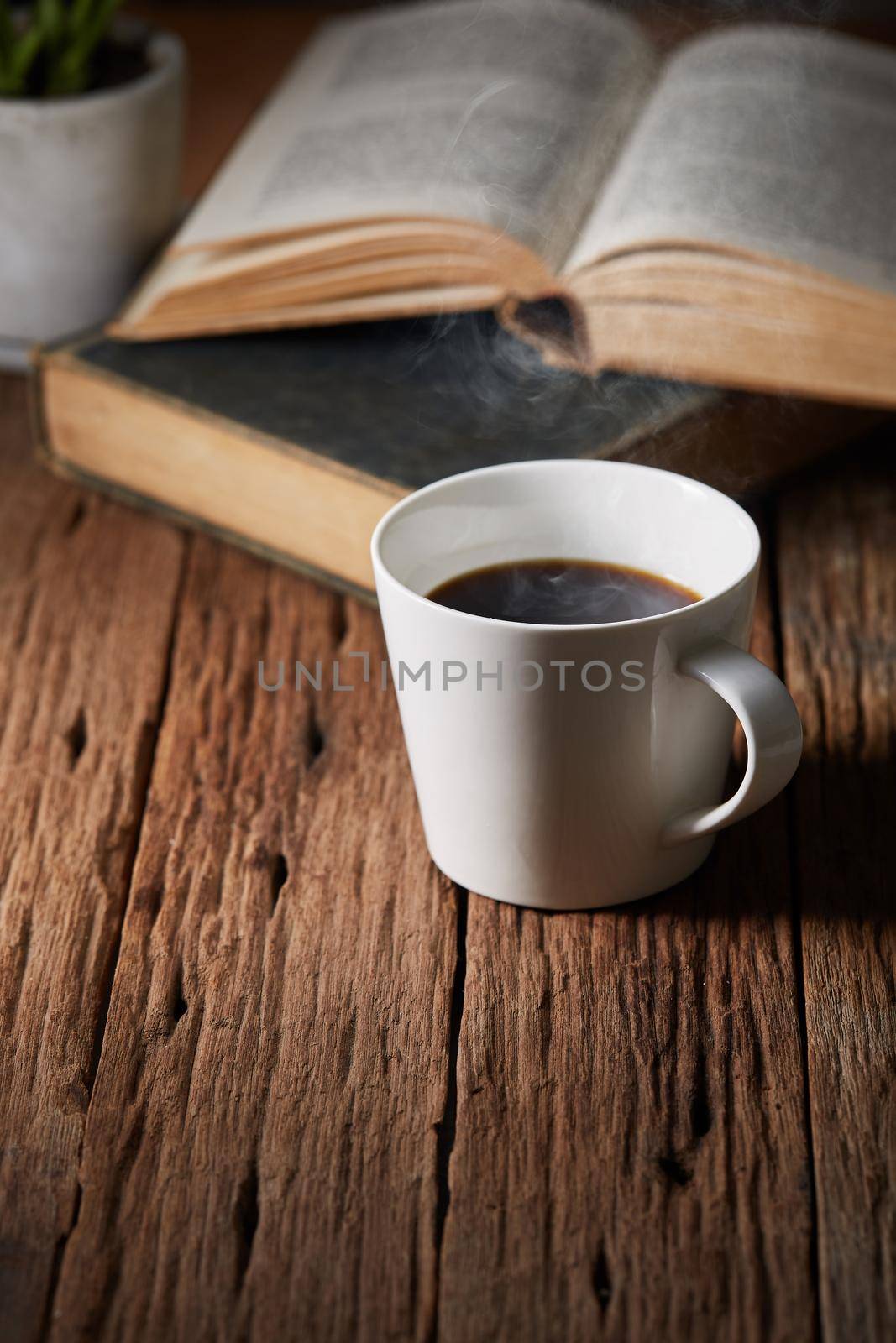 Cup of coffee with book by Wasant