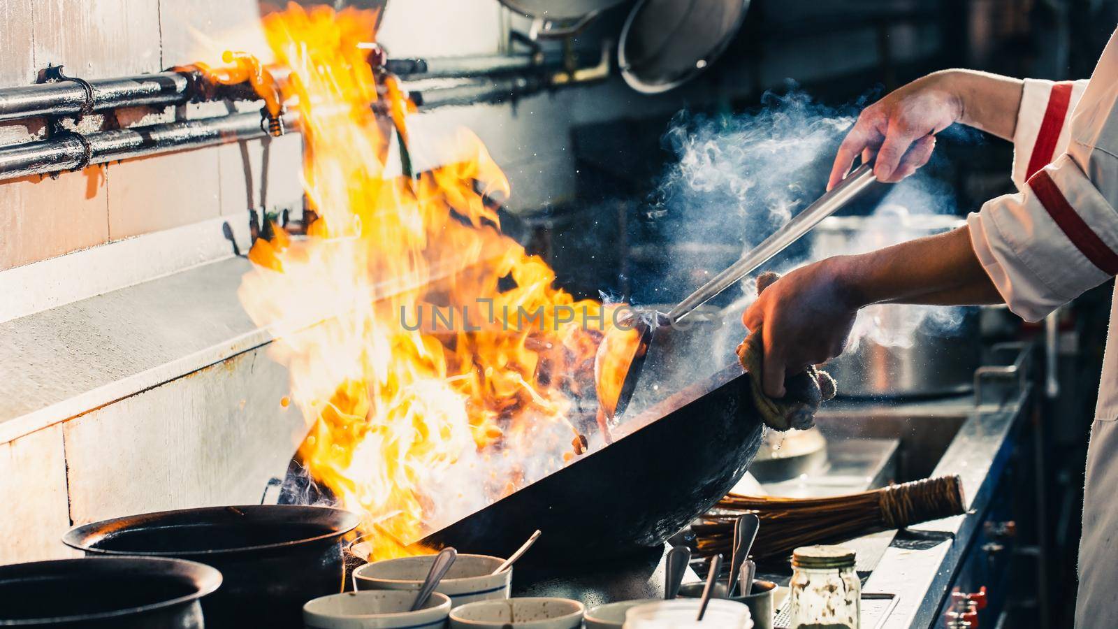 Chef stir fry cooking in kitchen, Professional chef fire cooking of restaurant, Street food cooking style