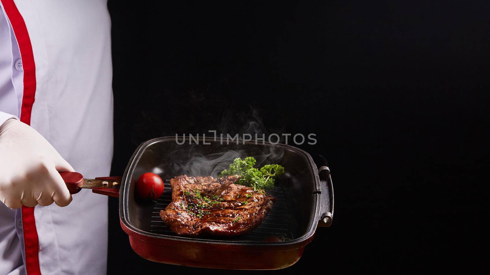 Grilled steak on pan with hand chef
