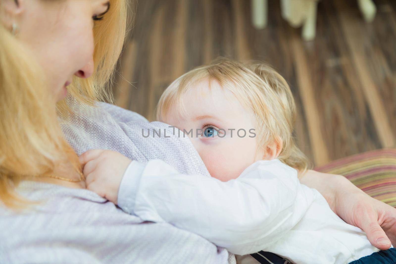 Mom is breastfeeding the baby. She looks at the baby with love and tenderness. Close-up