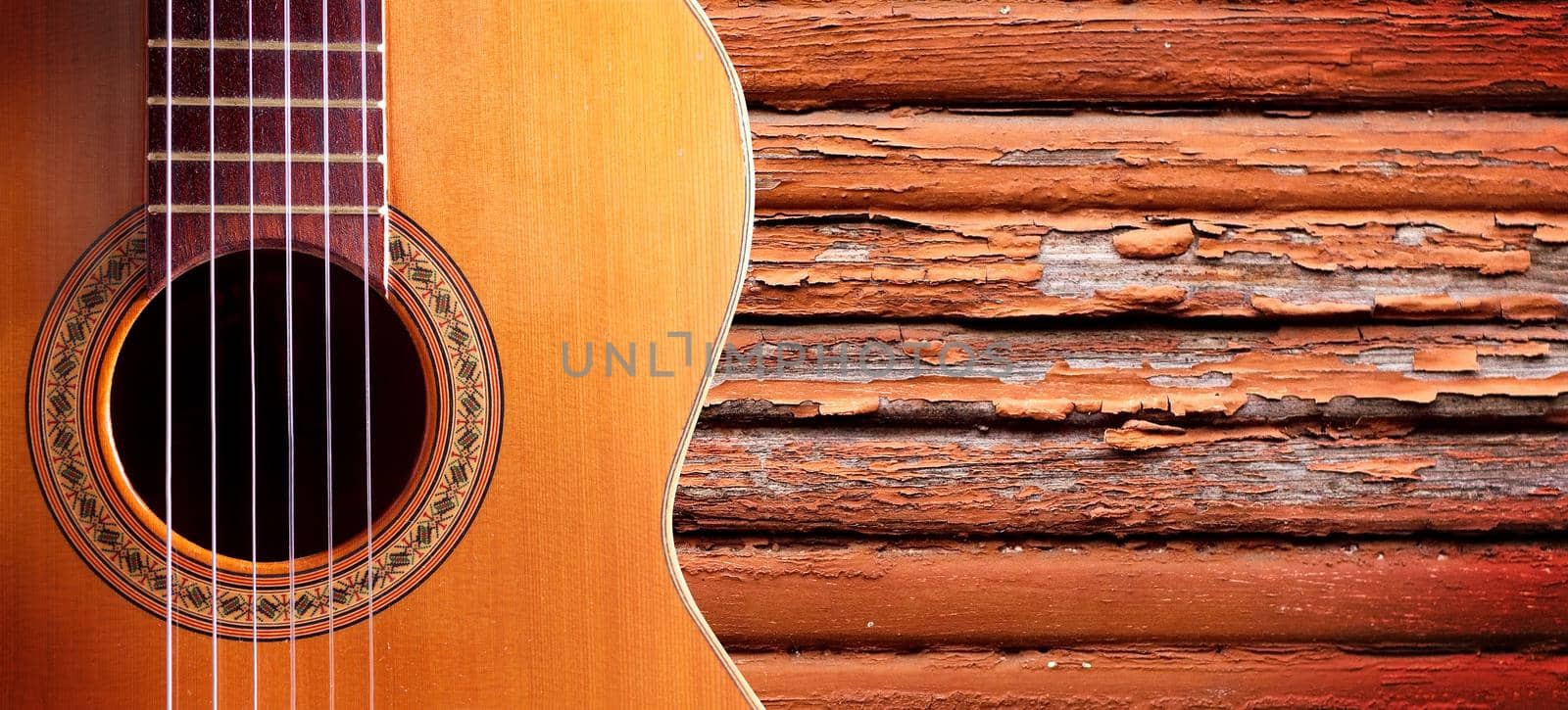 Spanish guitar and wood wall.Music background